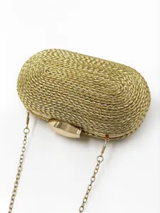 Détail de pochette de soirée tissée dorée avec texture artisanale et chaîne métallique.