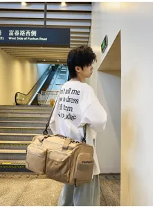 Detailansicht der großen khakifarbenen Reisetasche mit mehreren Taschen und stabilen Gurten.