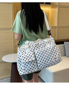 Grand sac de voyage à pois avec bandoulière et multiples poches pratiques pour courts séjours.