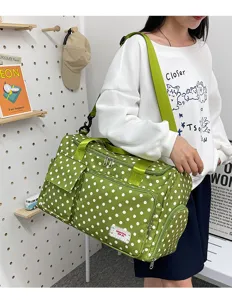 Détail de sac de voyage à pois verts, avec poches multiples et sangle réglable pratique.
