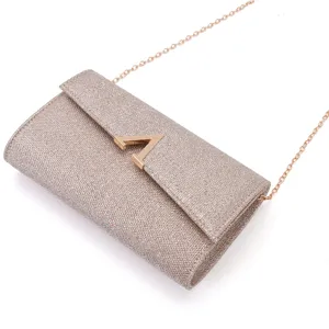 Glitter evening clutch bag detail, gold-tone chain strap, elegant metallic letter A clasp.