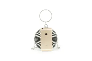 Detail view of handmade black and white striped round woven clutch bag with metal ring handle.
