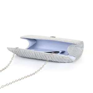 Silver glitter evening clutch bag detail showing pleated texture, lining, and chain strap.