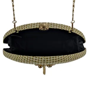 Detail view of the open woven straw evening clutch bag with metal chain and gold clasp.