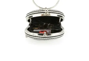 Detailed view of the black and white woven round clutch bag, showing interior storage space.