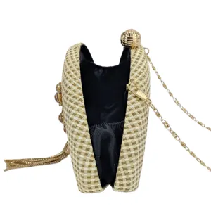 Woven straw evening clutch bag detail view, semi-circular hard case with metal chain strap.