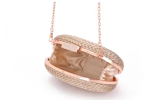 Detailed close-up of the woven evening clutch featuring a rose gold chain and satin lining.