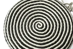 Black and white woven circular crossbody bag detail, handmade leather chain clutch.