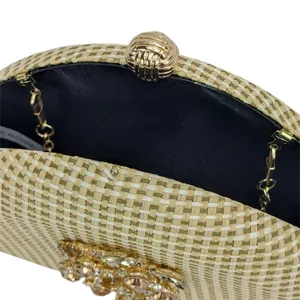 Detailed view of woven straw clutch purse with elegant rhinestone floral embellishment