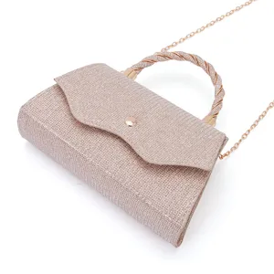 Close-up detail view of glamorous glitter evening clutch bag with twisted handle and gold chain.