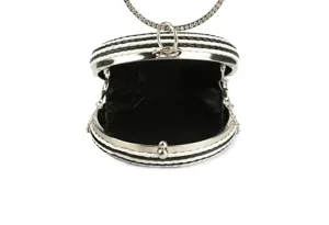 Detailed view of the black and white woven round evening clutch bag with metal ring handle.