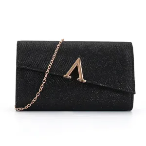 Black glitter evening clutch bag with chain strap and gold letter clasp for wedding party.