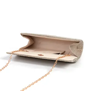 Detail shot of sparkling champagne evening clutch bag with metal chain strap and interior pocket.