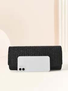 Black glitter evening clutch bag for women, elegant pleated metallic design with phone prop for size view.