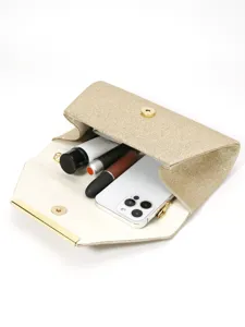 Vue détaillée de la pochette dorée pailletée montrant un intérieur spacieux pour essentiels.