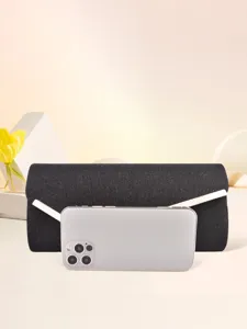 Detail shot of a black glitter evening clutch bag shown with a smartphone for size reference.