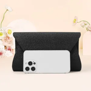 Black glitter envelope clutch bag detail view, elegant evening purse design with shiny finish.