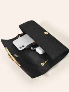 Black glitter clutch bag interior detail showing storage capacity for phone and essentials