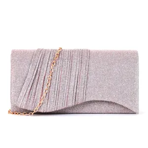 Détail de pochette de soirée pailletée, design plissé élégant avec chaîne dorée amovible.