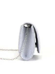Silver glitter clutch bag side detail, elegant evening handbag with metal chain strap.