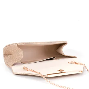 Detailed view of sparkly champagne evening clutch bag with metal chain strap and clasp.
