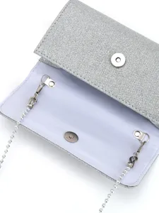 Détail intérieur pochette de soirée paillettes argentées avec fermoir et chaîne de perles.
