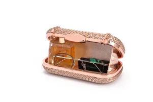 Detailed shot of woven clutch bag interior, rose gold metal frame, elegant evening accessory
