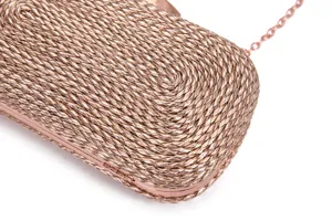 Close-up detail of metallic rose gold woven evening clutch bag with chain strap for party.