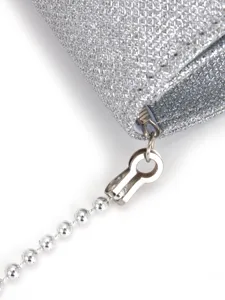 Vue de détail rapprochée d'un sac de soirée pailleté argenté avec fermeture éclair et chaîne.
