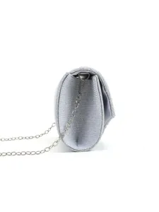 Detailed side angle view of silver glitter evening clutch bag with metal chain strap