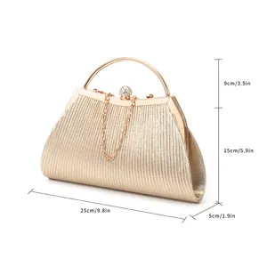 Detailed view of pleated metallic evening clutch bag with sparkling rhinestone handle and chain.