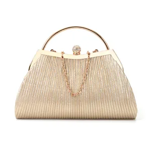 Gold pleated evening clutch bag with rhinestone ball clasp, metal round handle and chain strap.
