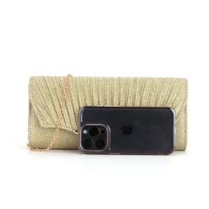 Gold glitter pleated evening clutch bag detail view, showing size comparison with smartphone.