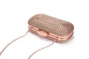 Rose gold woven clutch bag detail, metallic chain strap and hard case design for party.
