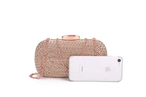 Detail view of rose gold woven clutch bag with metallic chain strap and lock closure.