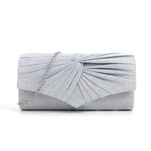 Detailed view of a silver glitter evening clutch bag with elegant pleats and metal chain.
