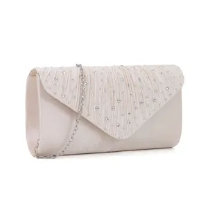 Detailed view of elegant beige pleated evening clutch bag with shimmering rhinestones and chain.