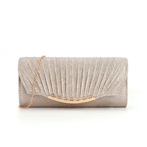 Close up of gold glitter evening clutch, pleated texture and elegant metallic chain strap.