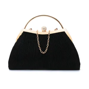 Detailed view of black pleated evening clutch bag with gold metal handle and rhinestones.