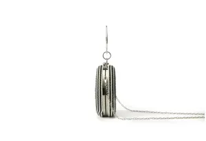 Handmade black and white woven round clutch bag, side view showing metal chain and frame details.