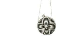 Detailed view of the black and white woven round clutch bag with silver chain strap.