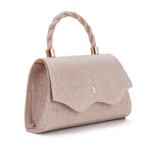 Close-up detail of glittering evening handbag with stylish twisted metal handle for party.