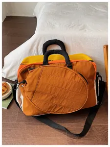 Detailopname van een grote gekleurde sporttas met een ronde voorzak voor extra opberg.