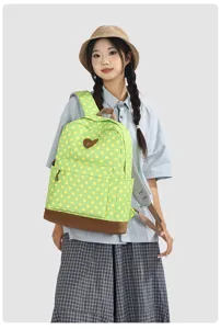 Vue détaillée du sac à dos à pois verts, cartable étudiant décontracté avec patch de cœur.