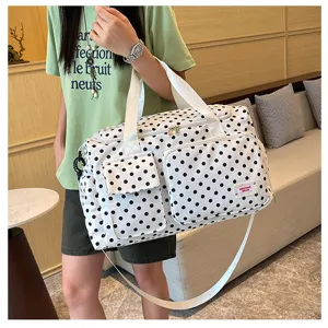Vue détaillée du grand sac de voyage souple à pois noirs et blancs avec multiples poches.