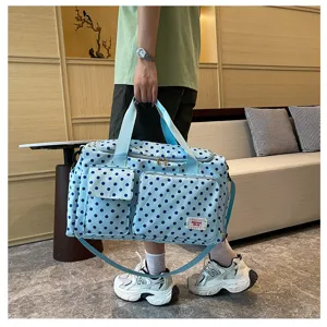 Vue détaillée du sac de voyage bleu à pois avec poche avant pratique et poignées solides.