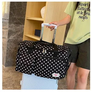 Grand sac de voyage capacite bagage avec motif a pois noir et blanc pour courts sejours de femmes.