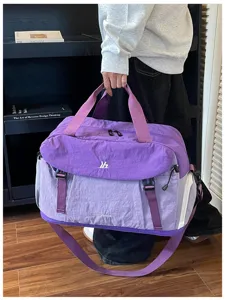 Vista dettagliata della grande borsa da viaggio e sportiva viola estensibile con cinghie forti.
