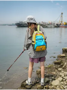 Outdoor travel color-block backpack outdoor scene showing vibrant contrast fabric and cords.
