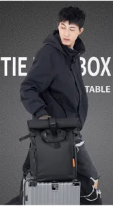 Detail shot of the men's waterproof roll-top backpack, showing large capacity and black design.